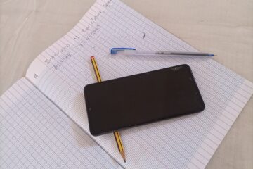 Notebook with pencil, pen, and phone